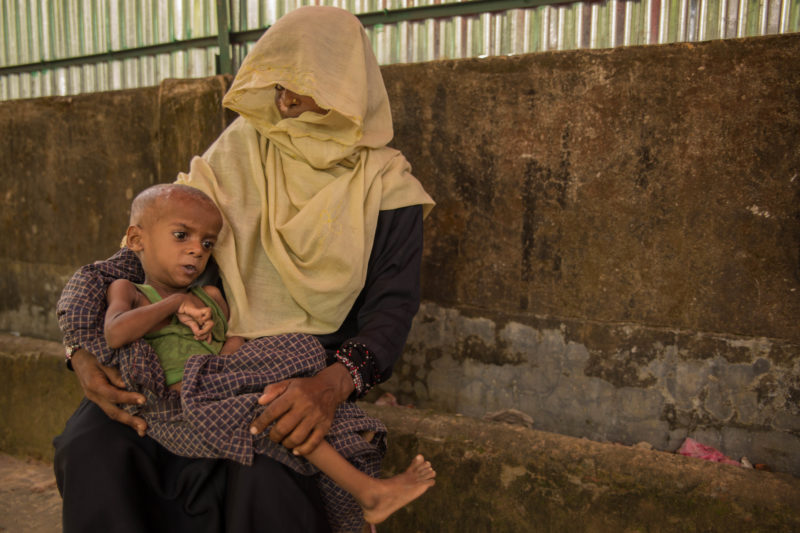 Anora, a refugee in Bangladesh, holding her son suffering from malnutrition