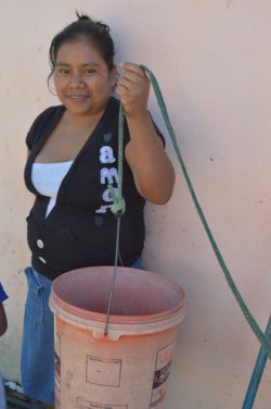 Juana, a local Guatemalan, holding a bucket she used to fill with water and pull up from her previous water system
