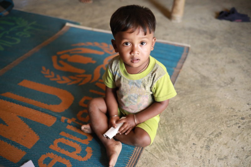 Salamot, a Bangladesh refugee boy, sitting on the floor of a health clinic to receive a vaccination