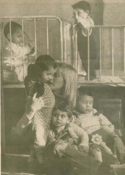 A Medical Teams volunteer holding three orphans left in Romania 