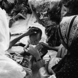 An orphan child receiving food supplement from a Medical Teams Volunteer