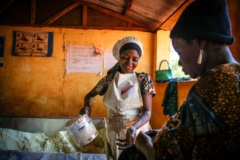 Loveness, a community worker, giving food rations in her community