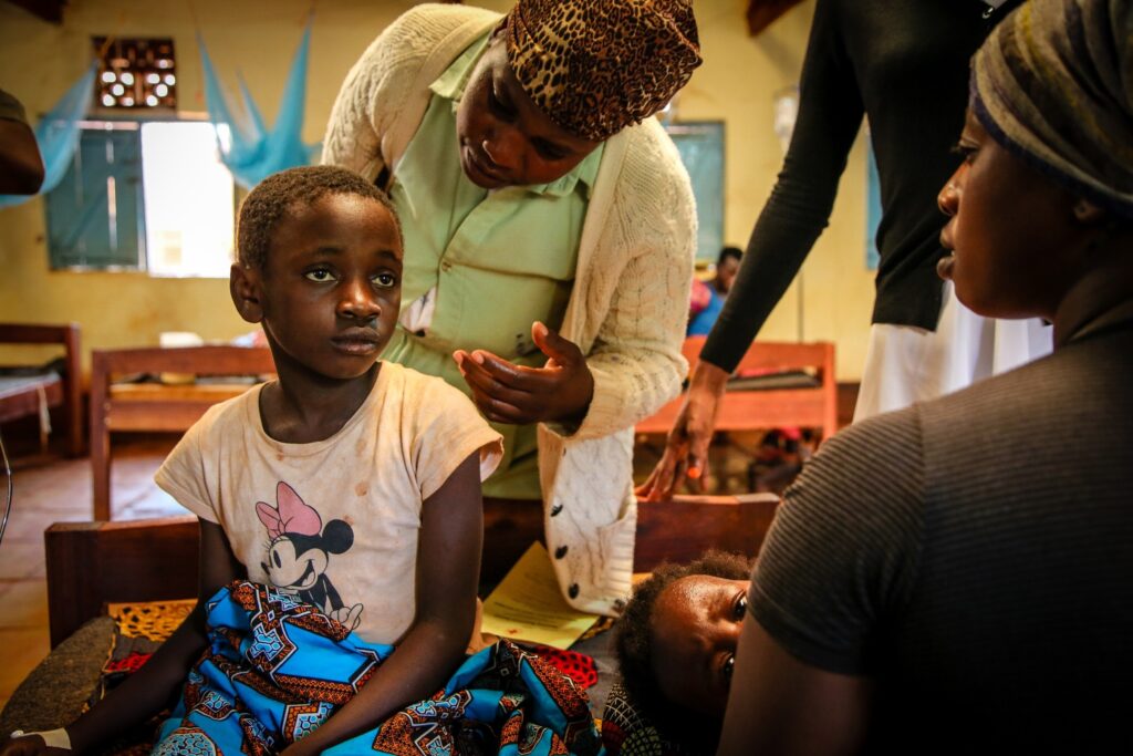 A girl sits up in a clinic (photo by Helen Manson)