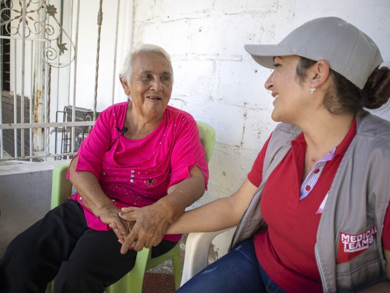 Daria speaking to Nazly, a Medical Teams health care worker, outside her home in Cienaga, Colombia